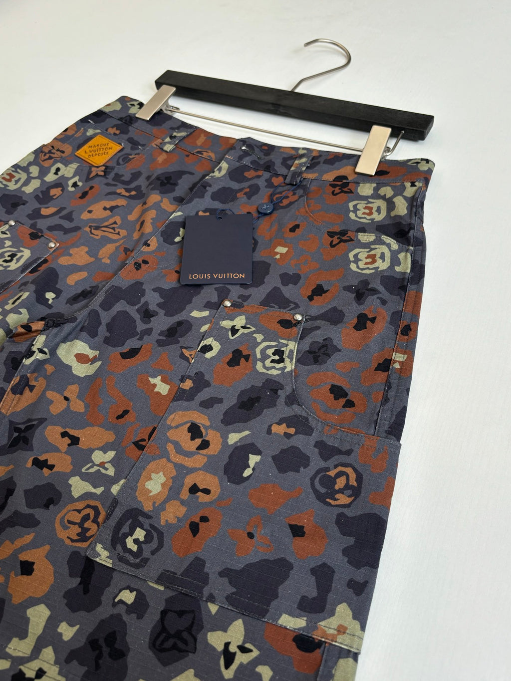 Louis Vuitton patterned shorts on hanger, front logo patch pocket area