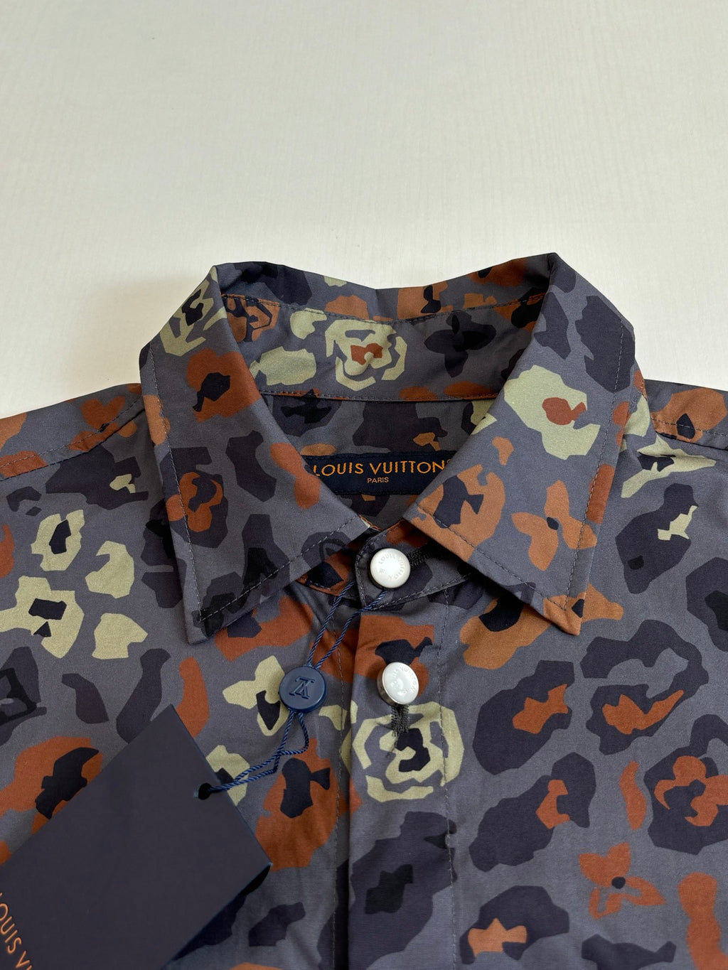 Camo-print shirt collar and front placket with two visible buttons