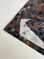 Multicolor camo short-sleeve shirt laid flat with collar and pocket visible