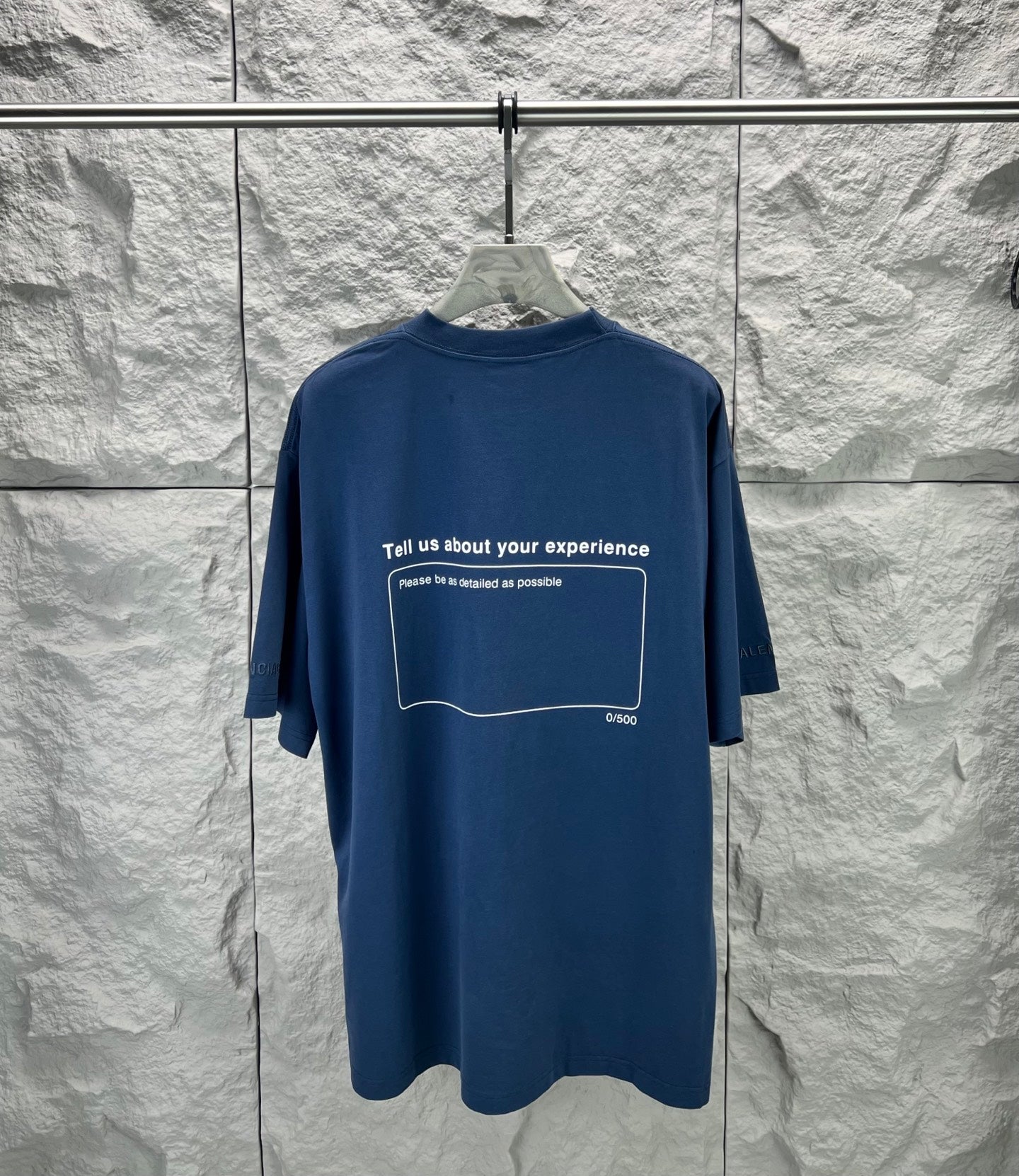 Blue short-sleeve T-shirt with centered back text inside an outlined box