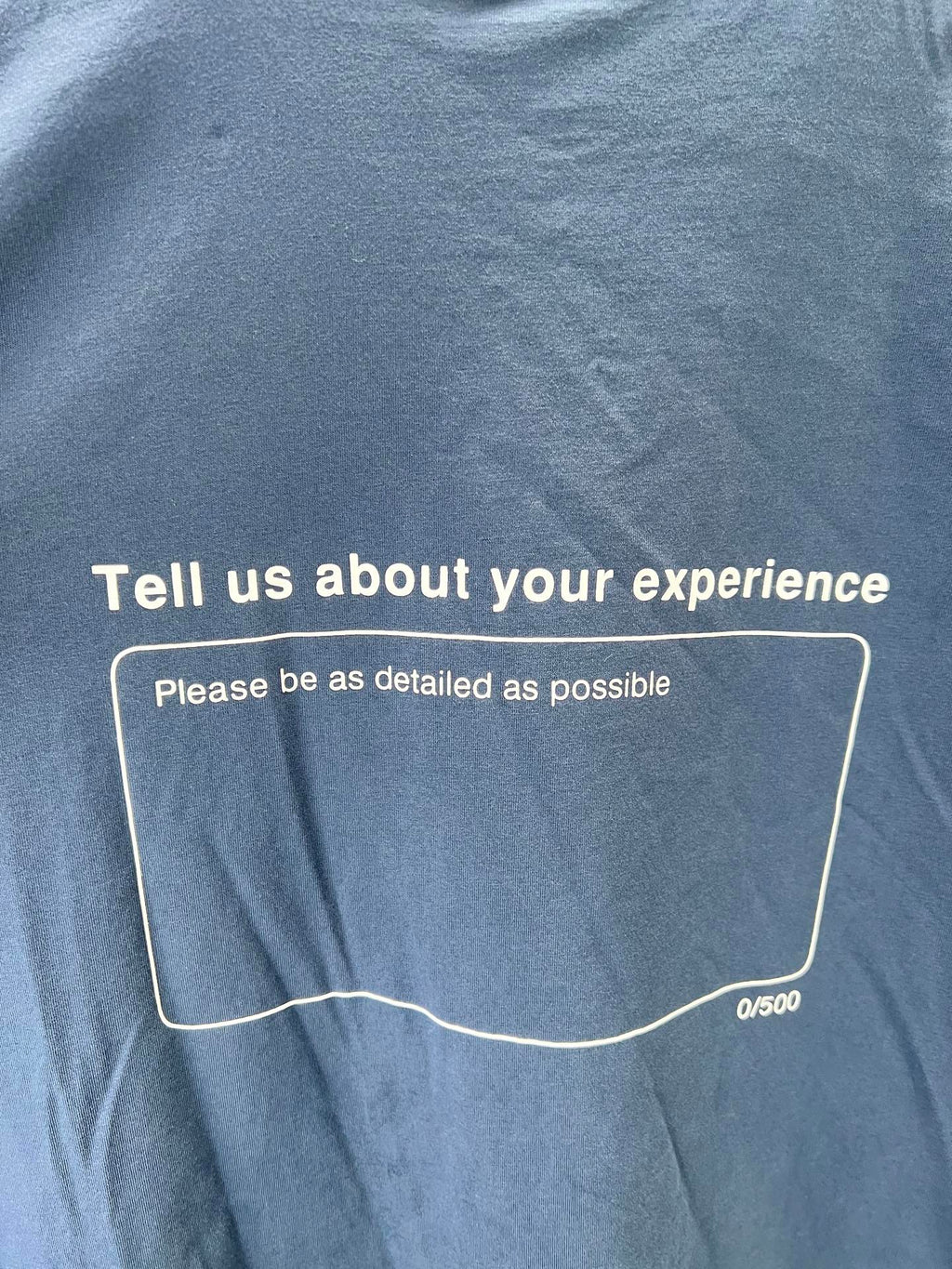 Blue short-sleeve T-shirt back with 'Tell us about your experience' box text