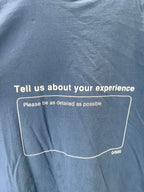 Blue short-sleeve T-shirt back with 'Tell us about your experience' box text