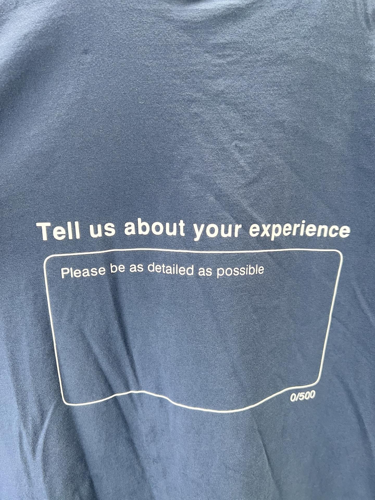 Blue short-sleeve T-shirt back with 'Tell us about your experience' box text