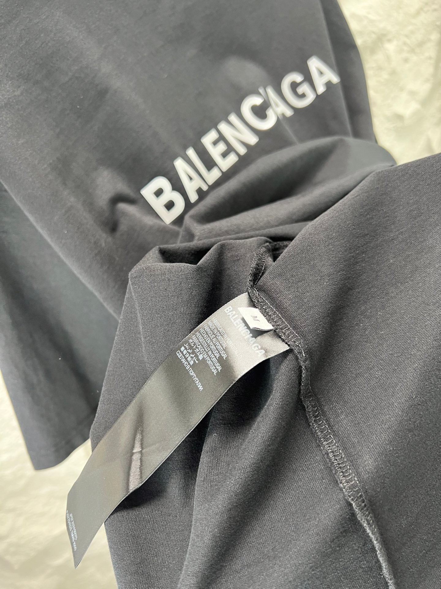 Balenciaga heather gray T-shirt sleeve with attached tag and folded fabric