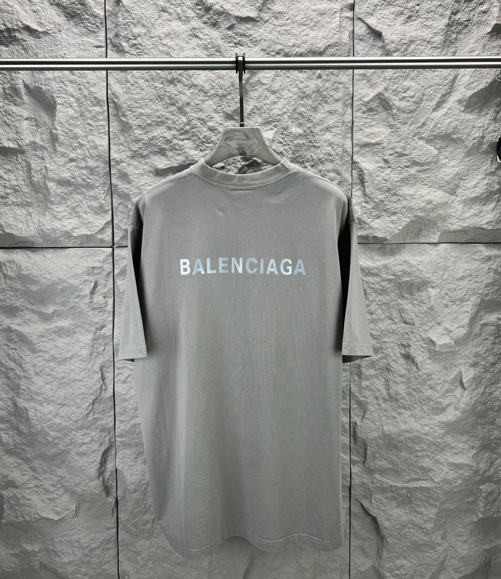 Light gray crewneck T-shirt with large BALENCIAGA logo on front, on hanger