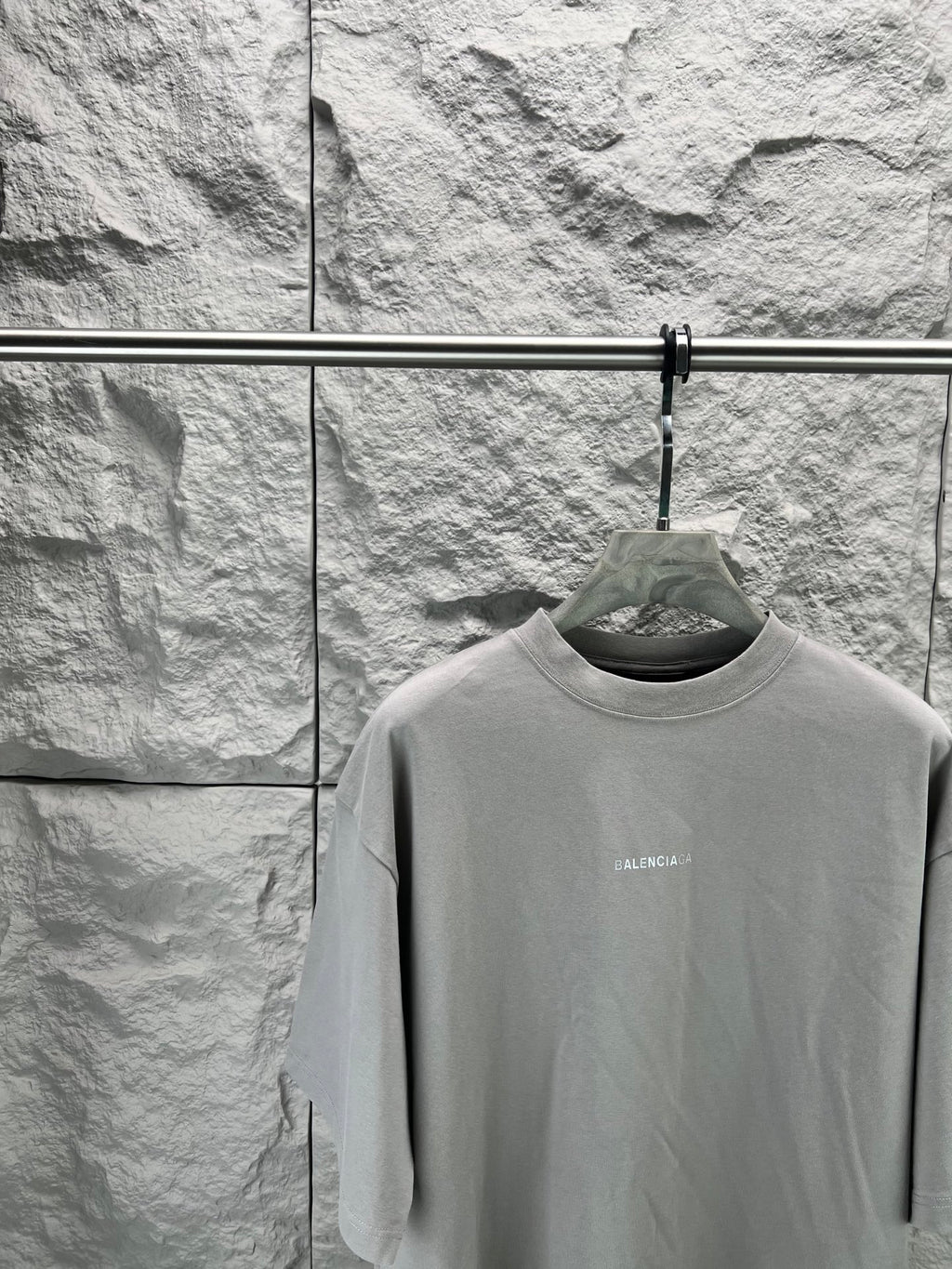 Light gray crewneck T-shirt close-up on hanger, small chest BALENCIAGA text