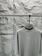 Light gray crewneck T-shirt close-up on hanger, small chest BALENCIAGA text