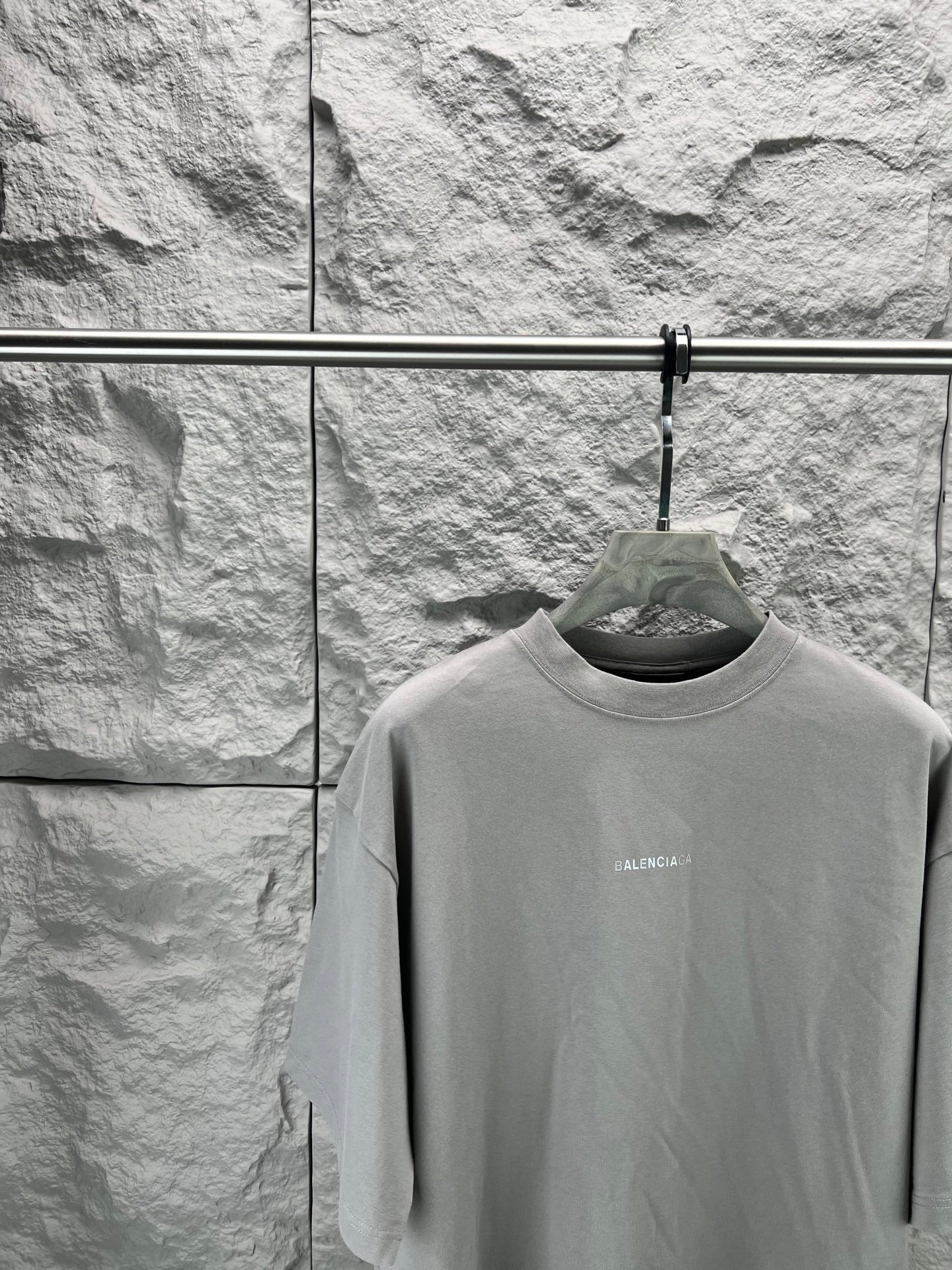 Light gray crewneck T-shirt close-up on hanger, small chest BALENCIAGA text