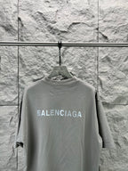 Light gray crewneck T-shirt front view on hanger, BALENCIAGA logo across chest