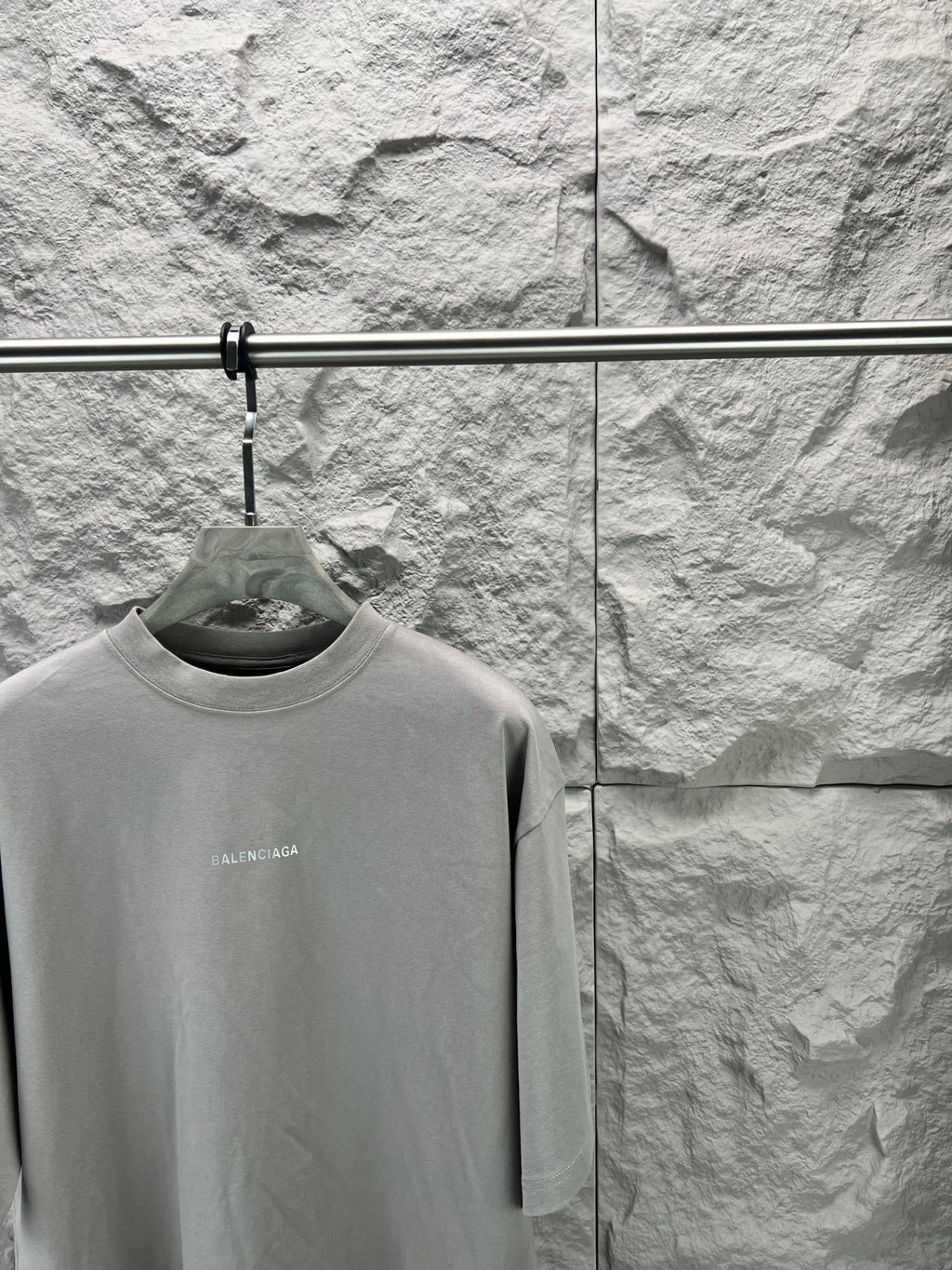 Light gray crewneck T-shirt close-up on hanger, small chest BALENCIAGA logo
