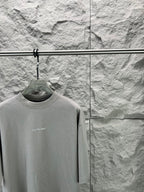 Light gray crewneck T-shirt close-up on hanger, small chest BALENCIAGA logo