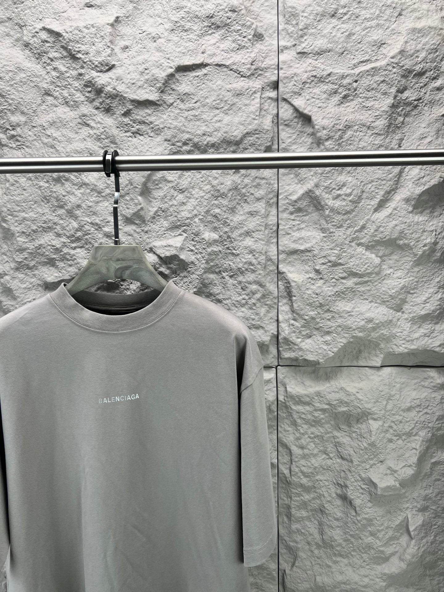 Light gray crewneck T-shirt close-up on hanger, small chest BALENCIAGA logo