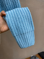 Light-blue knitted sweater cuff with ribbed texture