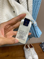 Louis Vuitton knit sweater size label and care tag on light-blue sleeve cuff