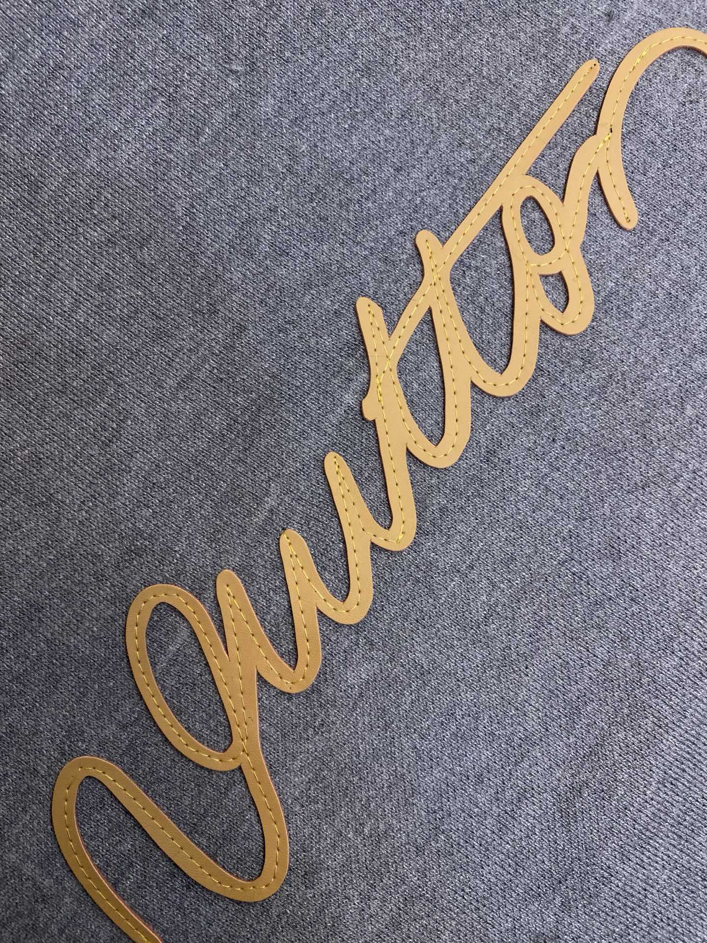 Gray fabric hoodie with yellow embroidered logo script