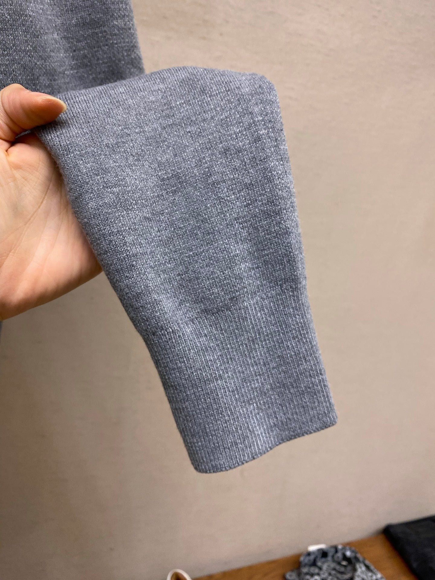 Gray ribbed cuff sleeve of a pullover hoodie