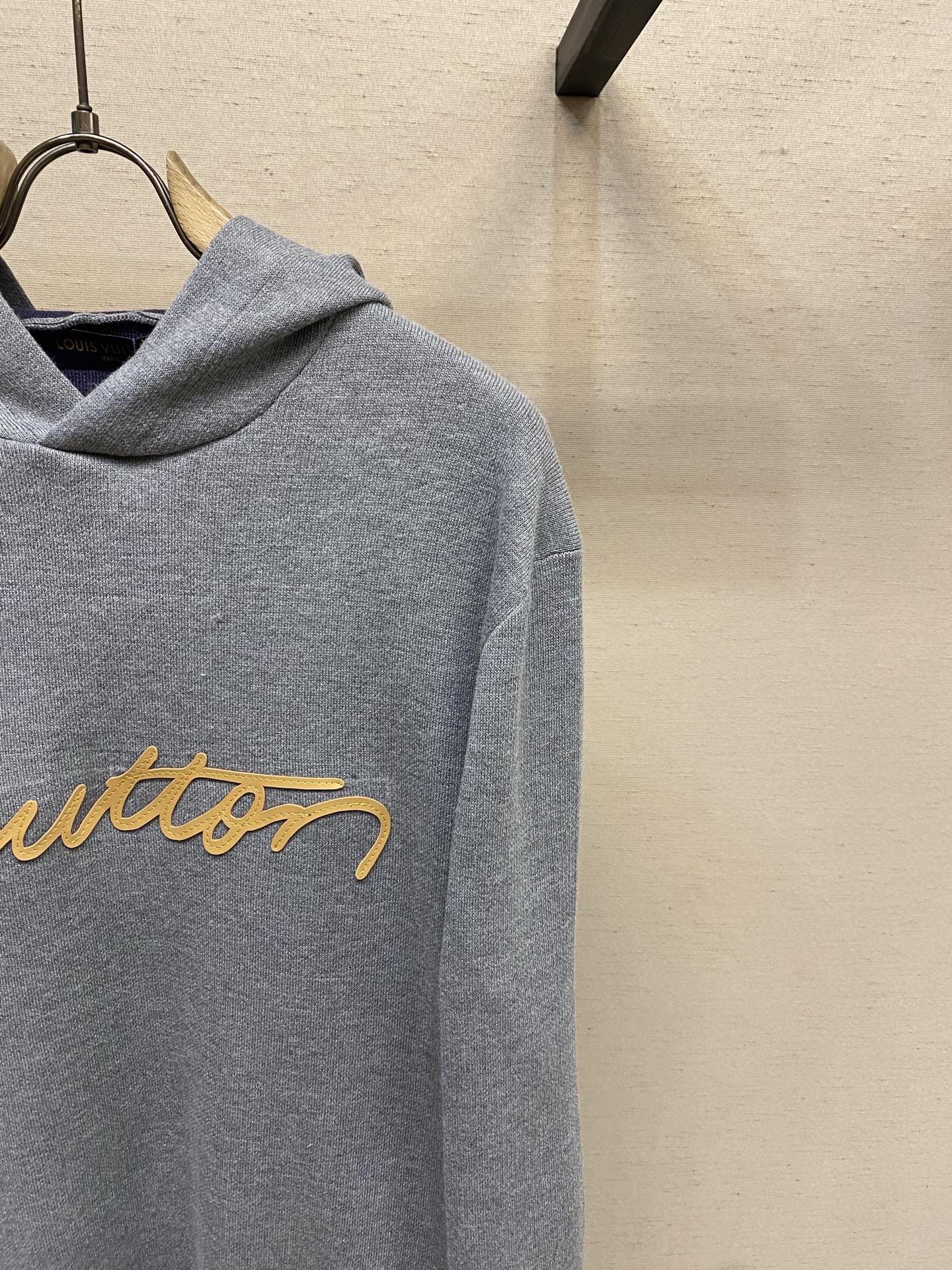 Gray Louis Vuitton hoodie with partial yellow logo script on chest