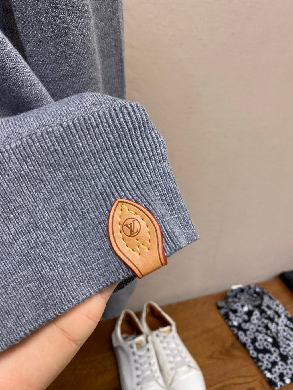Gray hoodie sleeve cuff with tan leather logo patch