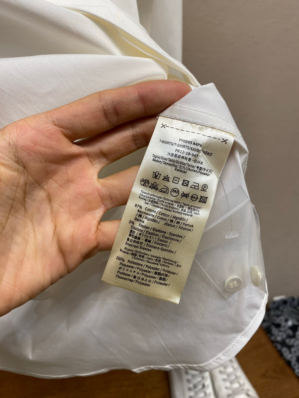 White shirt care label tag on the inside with washing and size instructions.