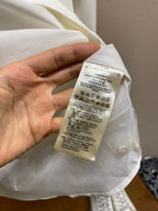 White shirt care label tag on the inside with washing and size instructions.