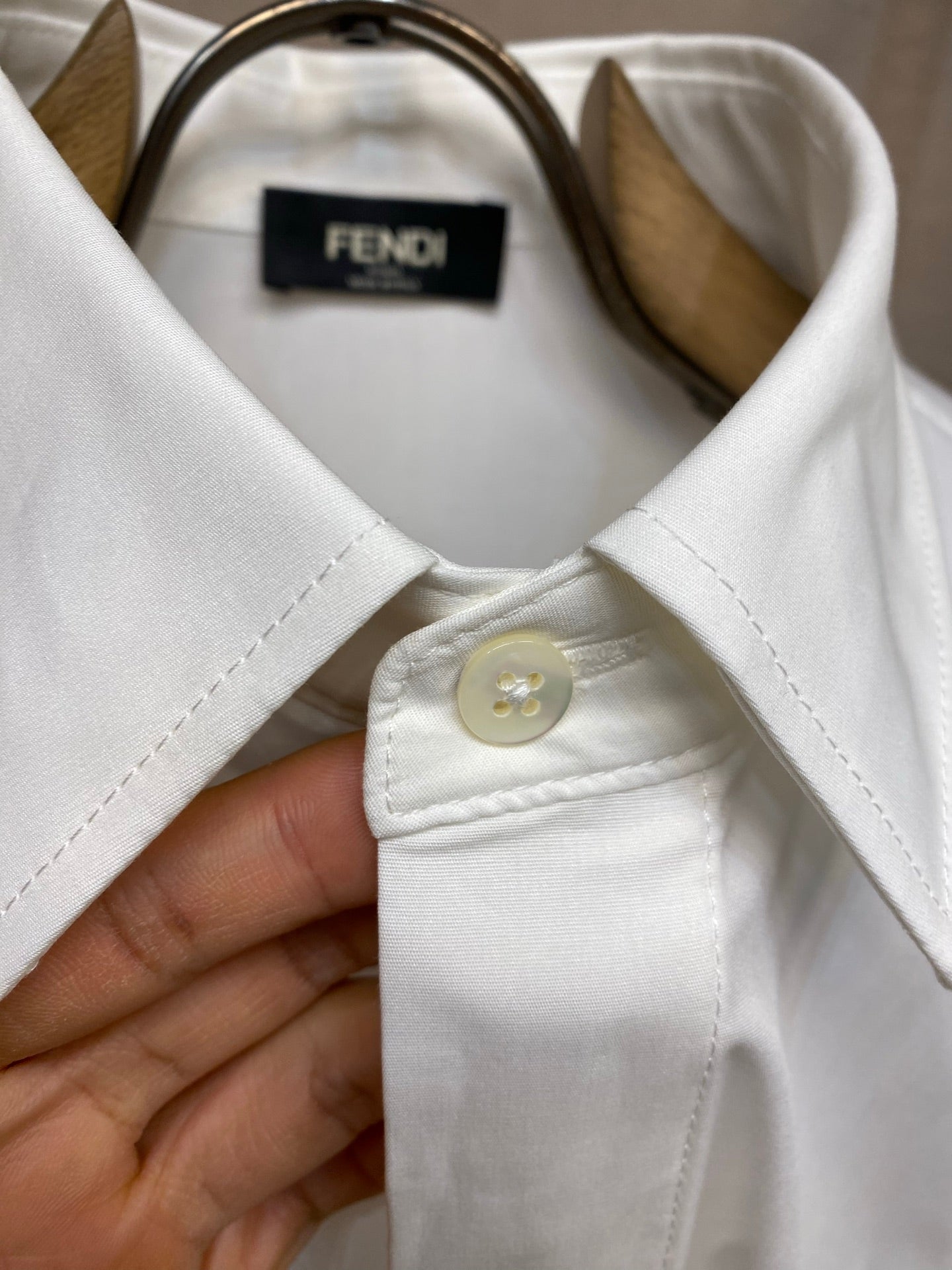 White button-up shirt neckline with button placket and FENDI label.