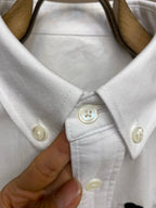 Amiri button-up shirt in white, pointed collar and button detail close-up