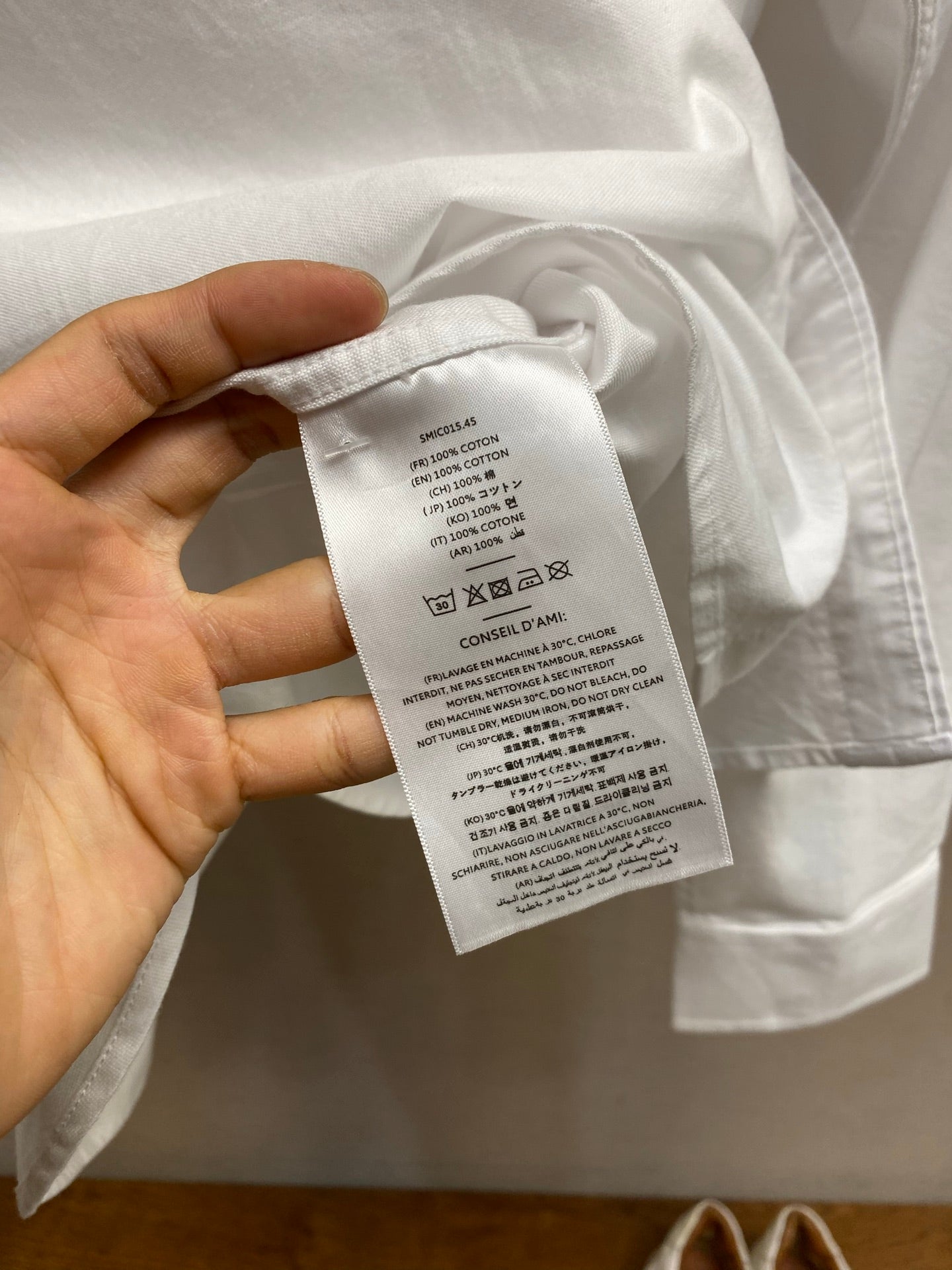 Amiri button-up shirt in white, care label tag visible at inner collar