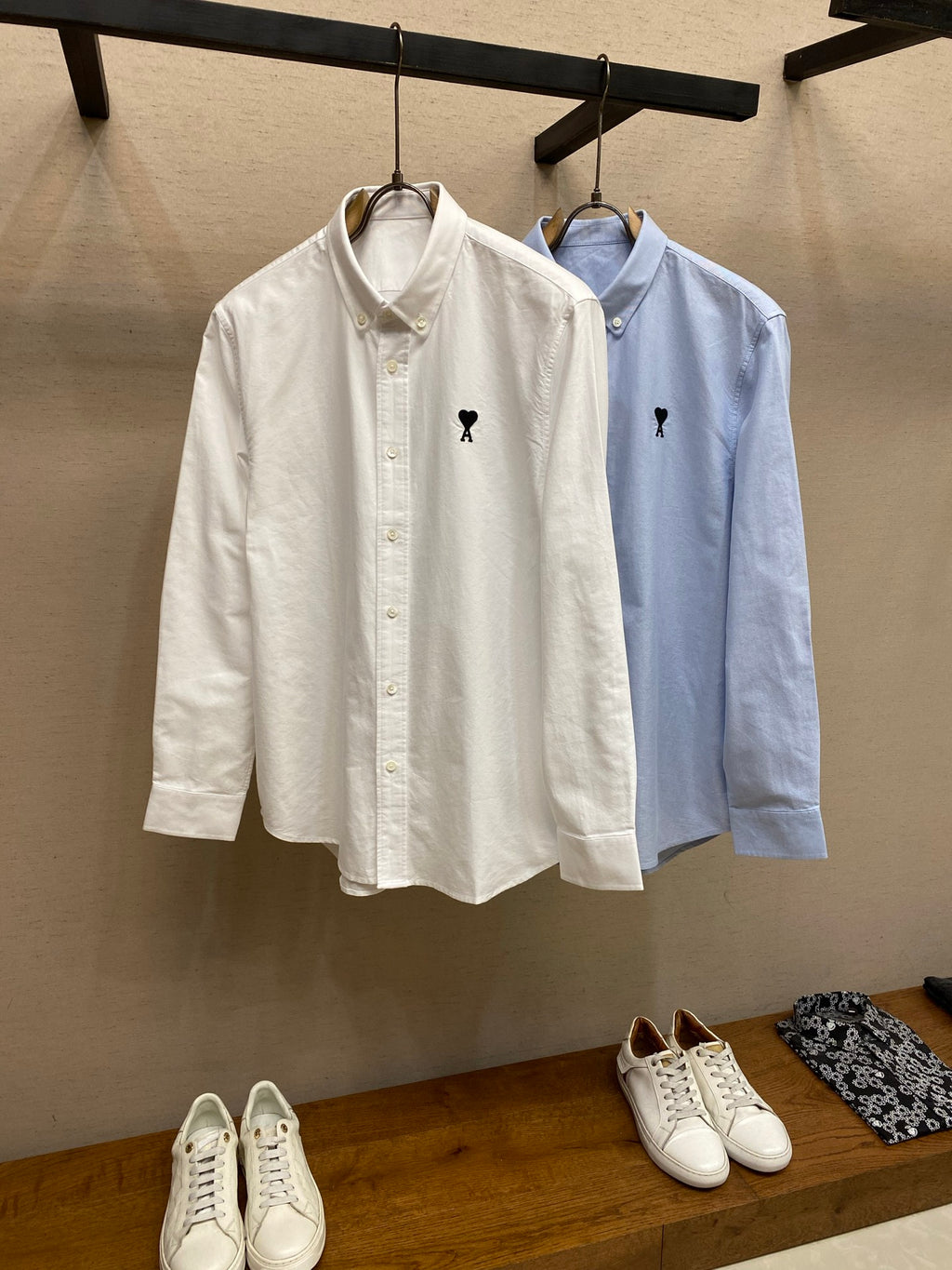 Light blue and white button-up shirts on hangers with small polo emblems