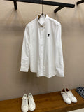 Amiri button-up shirt in white, front view with small black chest logo