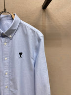 Light blue button-up shirt with button placket and black polo emblem