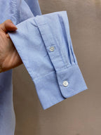 Light blue button-up shirt sleeve cuff with white button