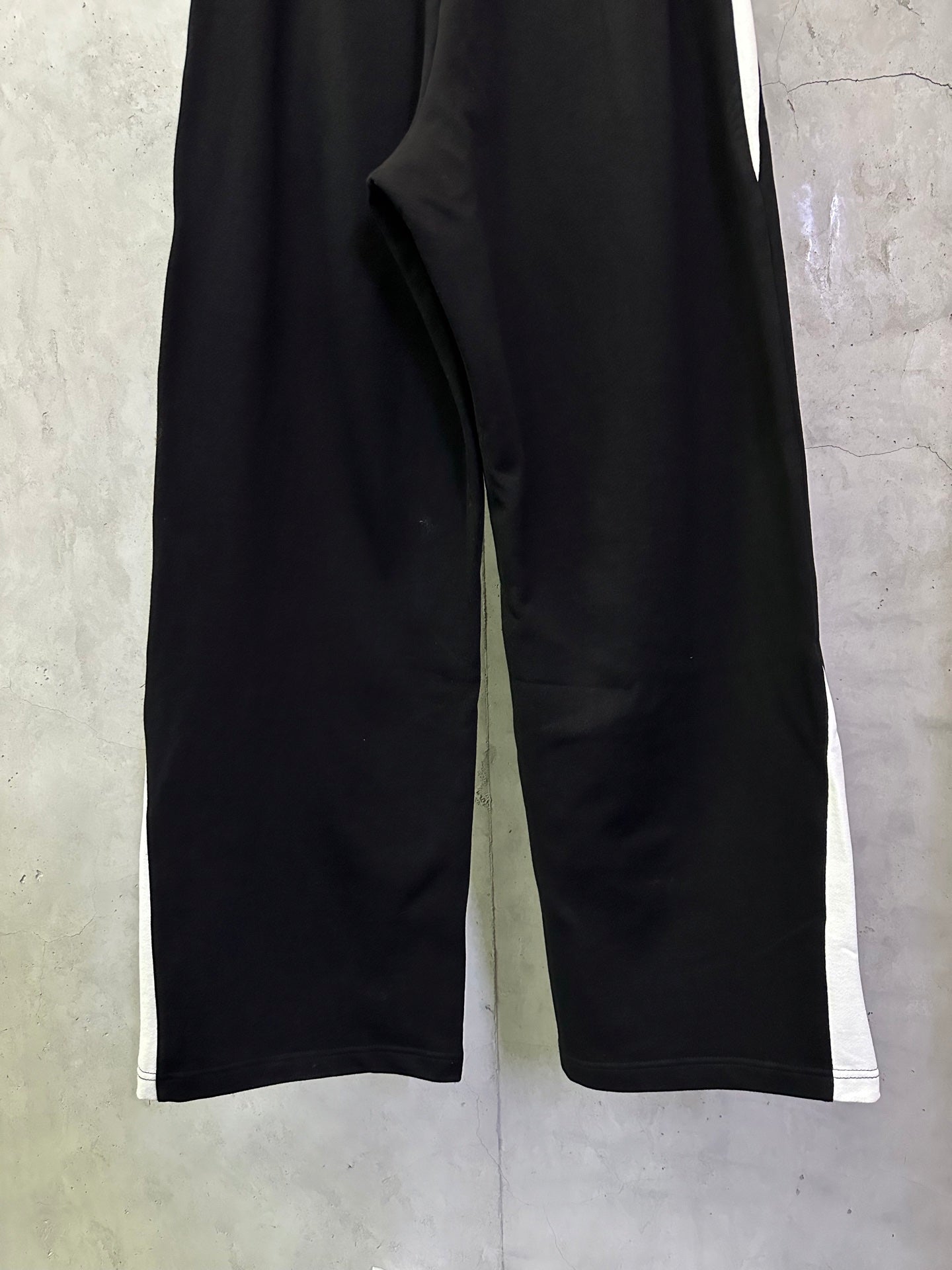 Black Balenciaga pants close-up, wide-leg silhouette and side seam