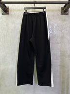 Black wide-leg pants with elastic waist and slant pocket openings, side view