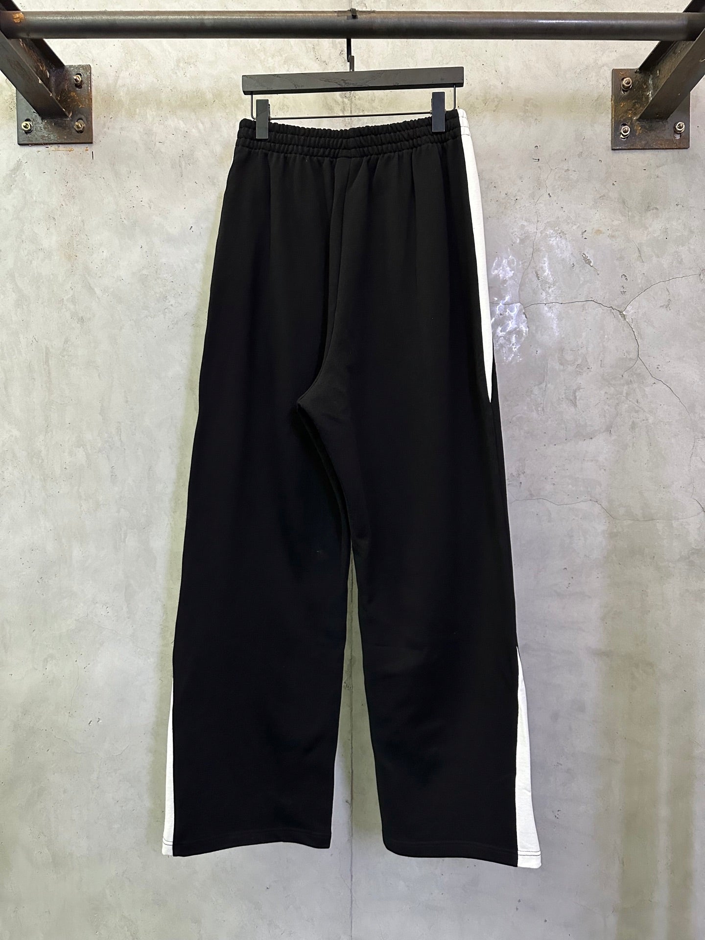 Black wide-leg pants with elastic waist and slant pocket openings, side view