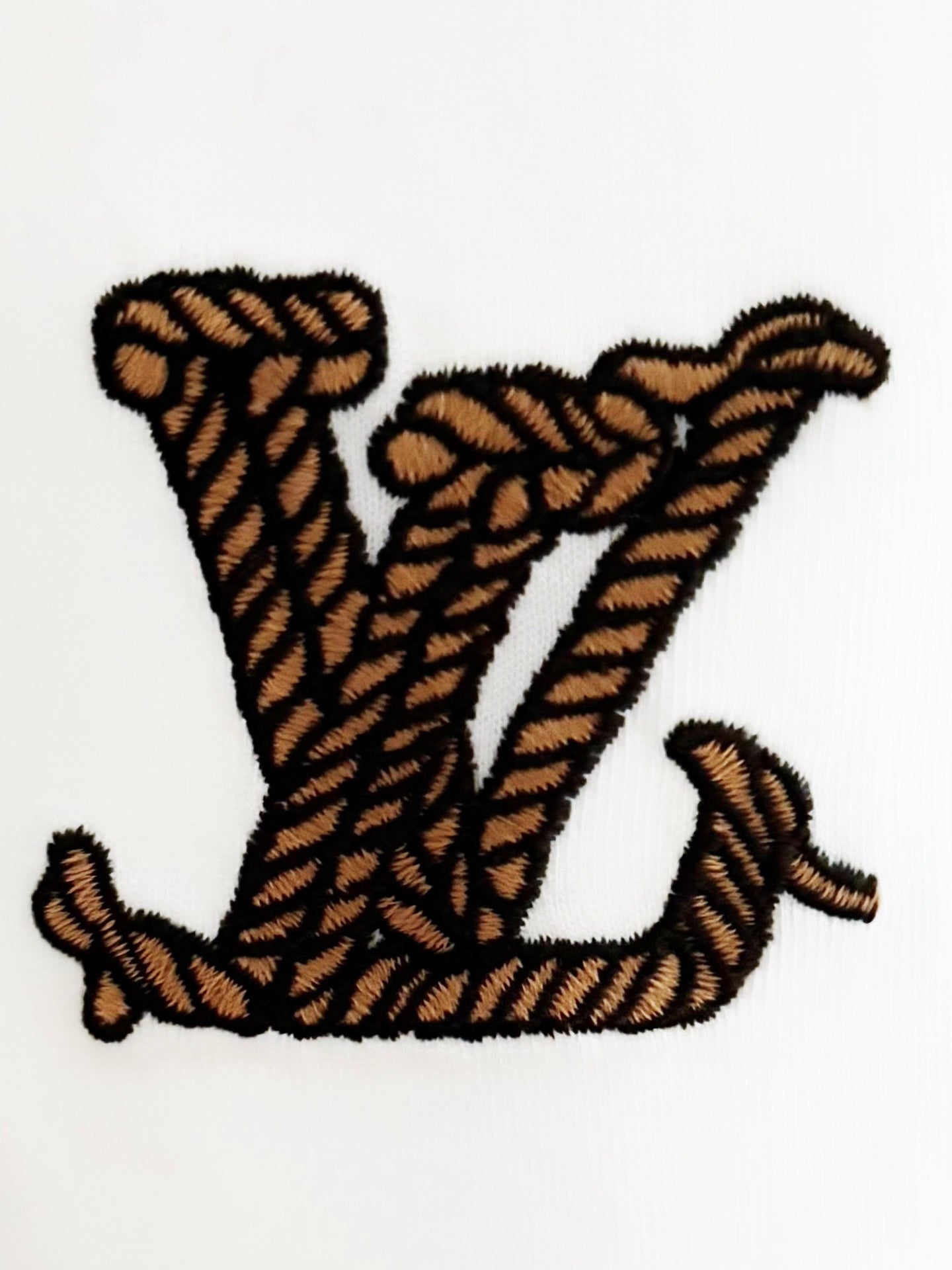 White Louis Vuitton T-shirt with large embroidered brown-and-black V-style graphic