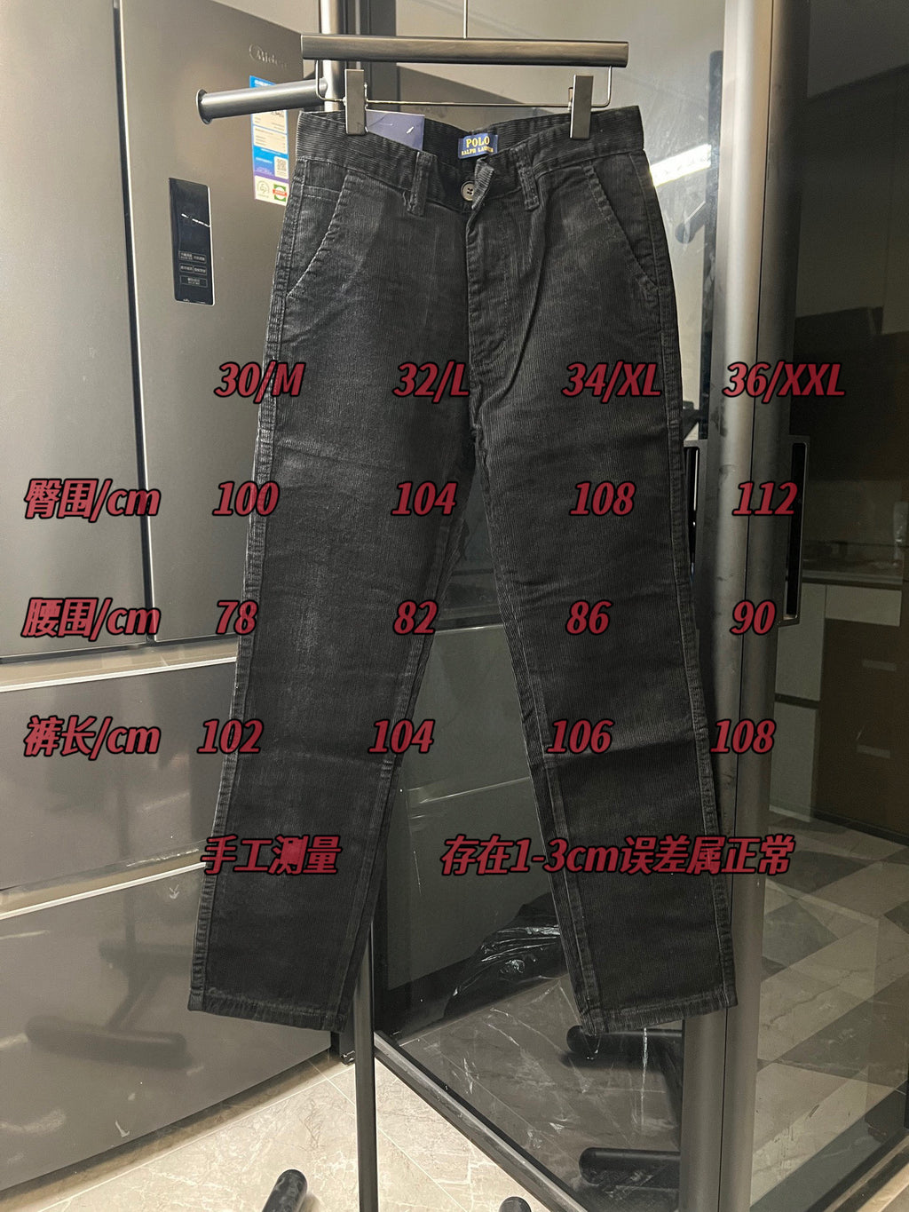 Dark corduroy jeans displayed on hanger with belt loops
