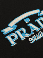 Black Prada Milano T-shirt close-up of blue embroidered PRADA lettering