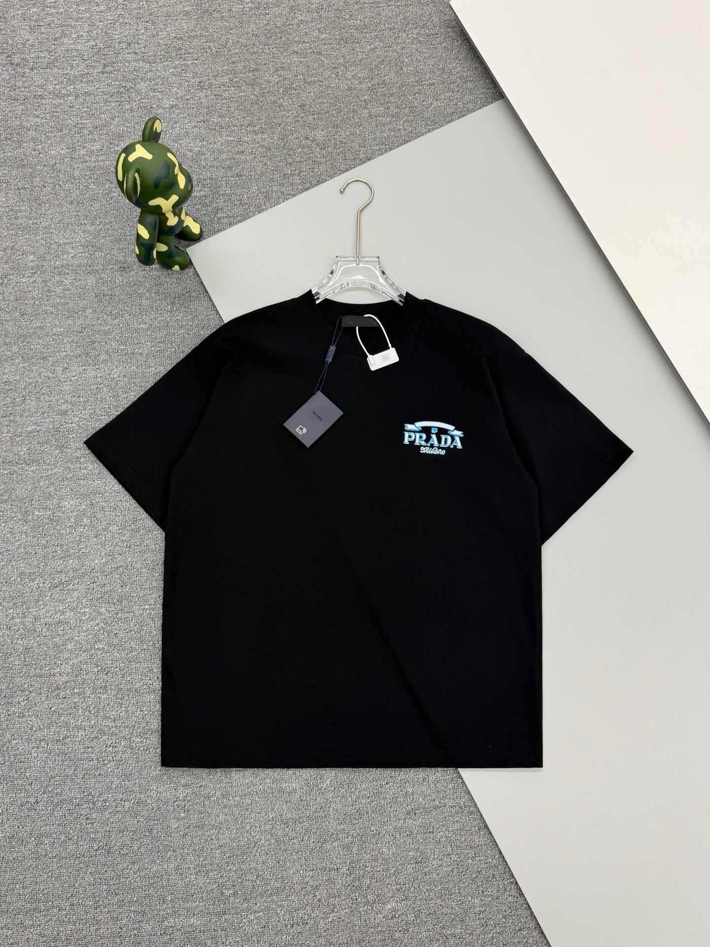 Black Prada short-sleeve T-shirt with small blue PRADA Milano logo and neck tag