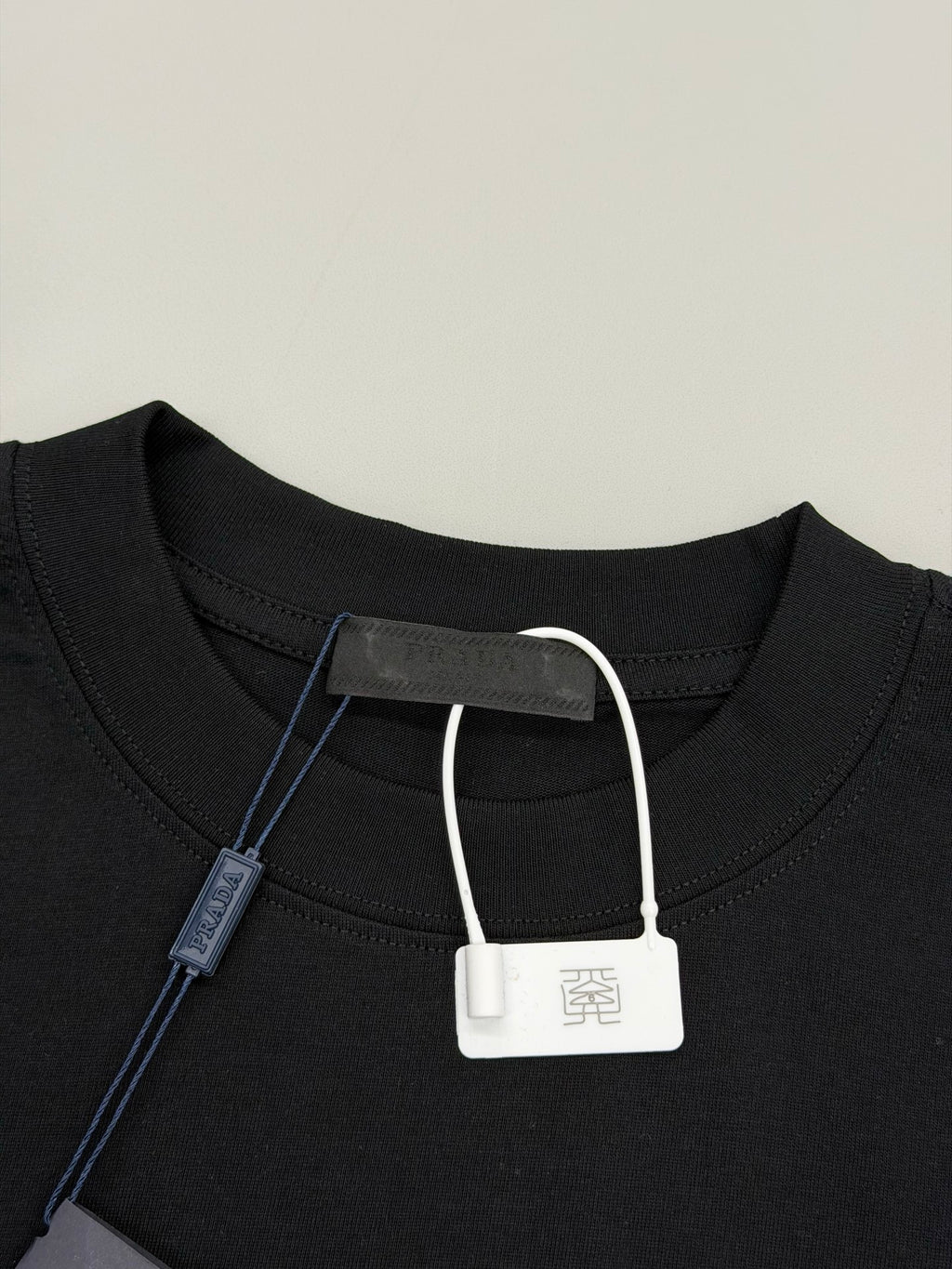 Black Prada T-shirt neckline with white drawstring-style tag and inner label