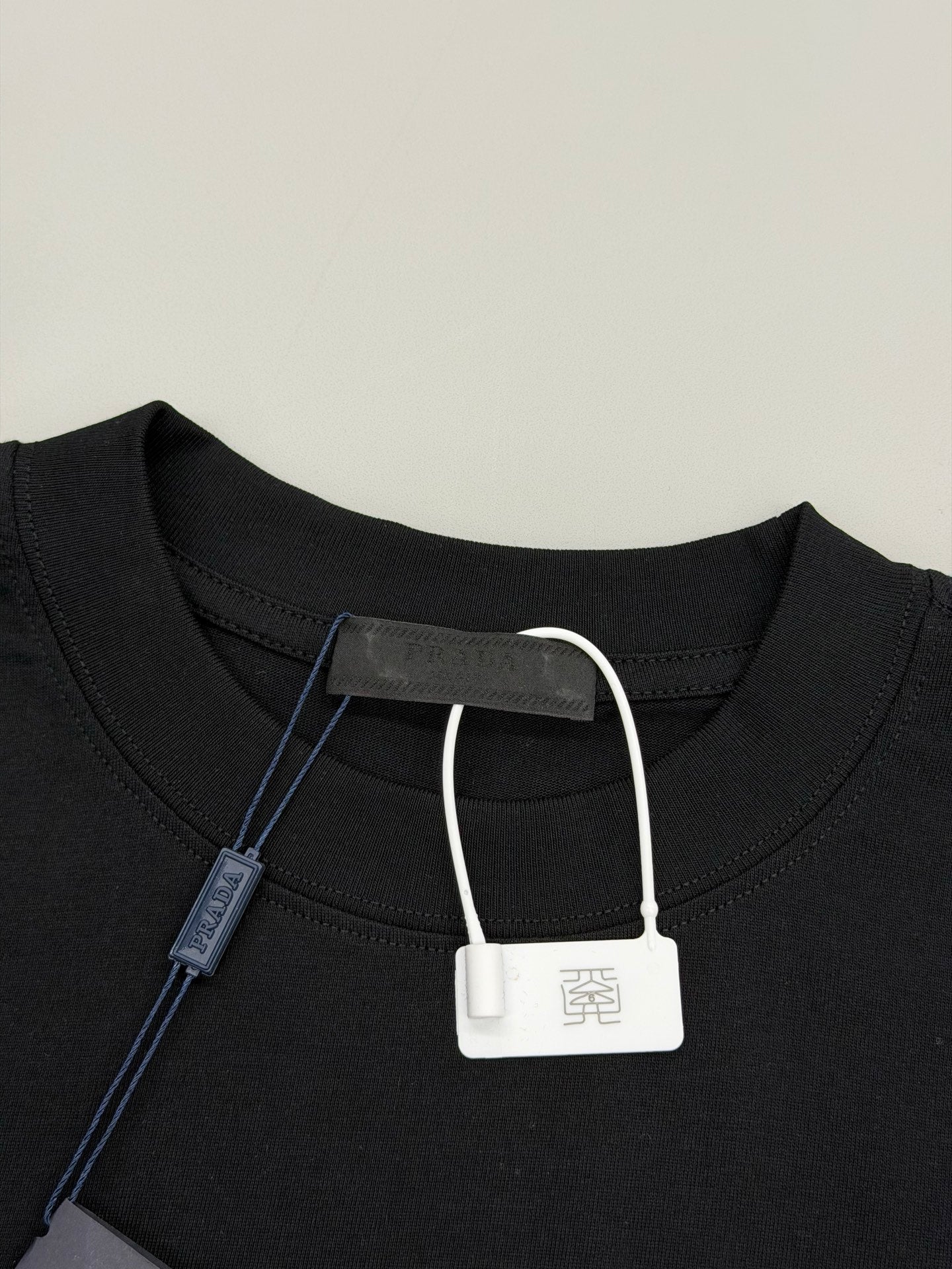 Black Prada T-shirt neckline with white drawstring-style tag and inner label
