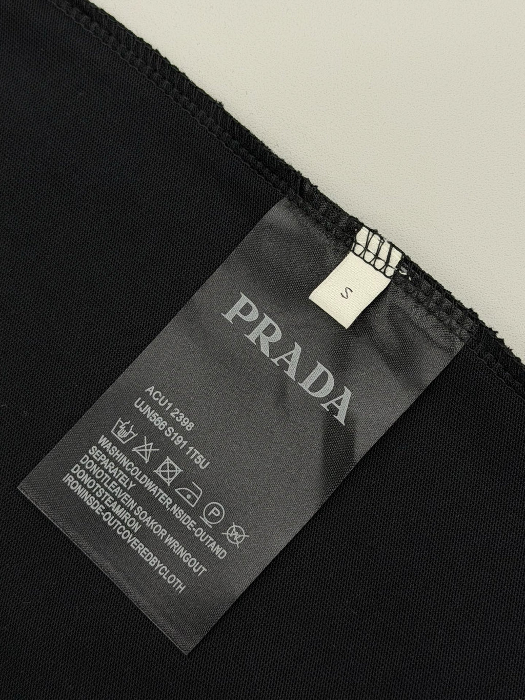 Black Prada T-shirt fabric tag with size and care instructions