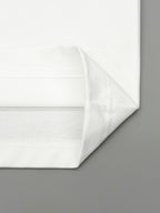 Folded white T-shirt fabric with smooth seams along the bottom hem