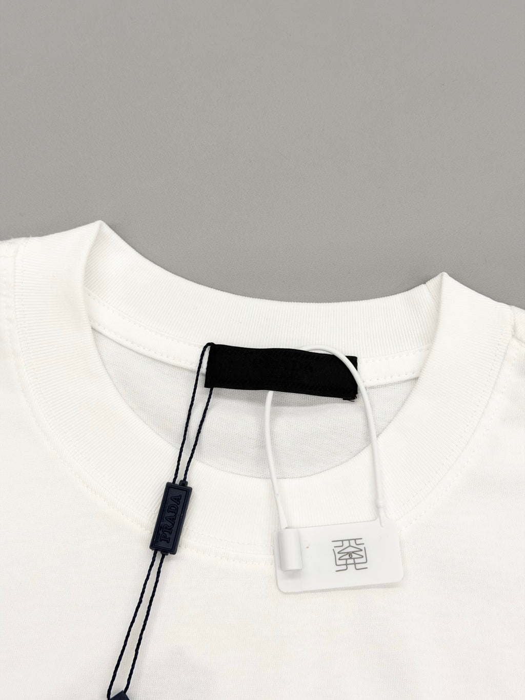 White short-sleeve T-shirt neckline with attached hang tag