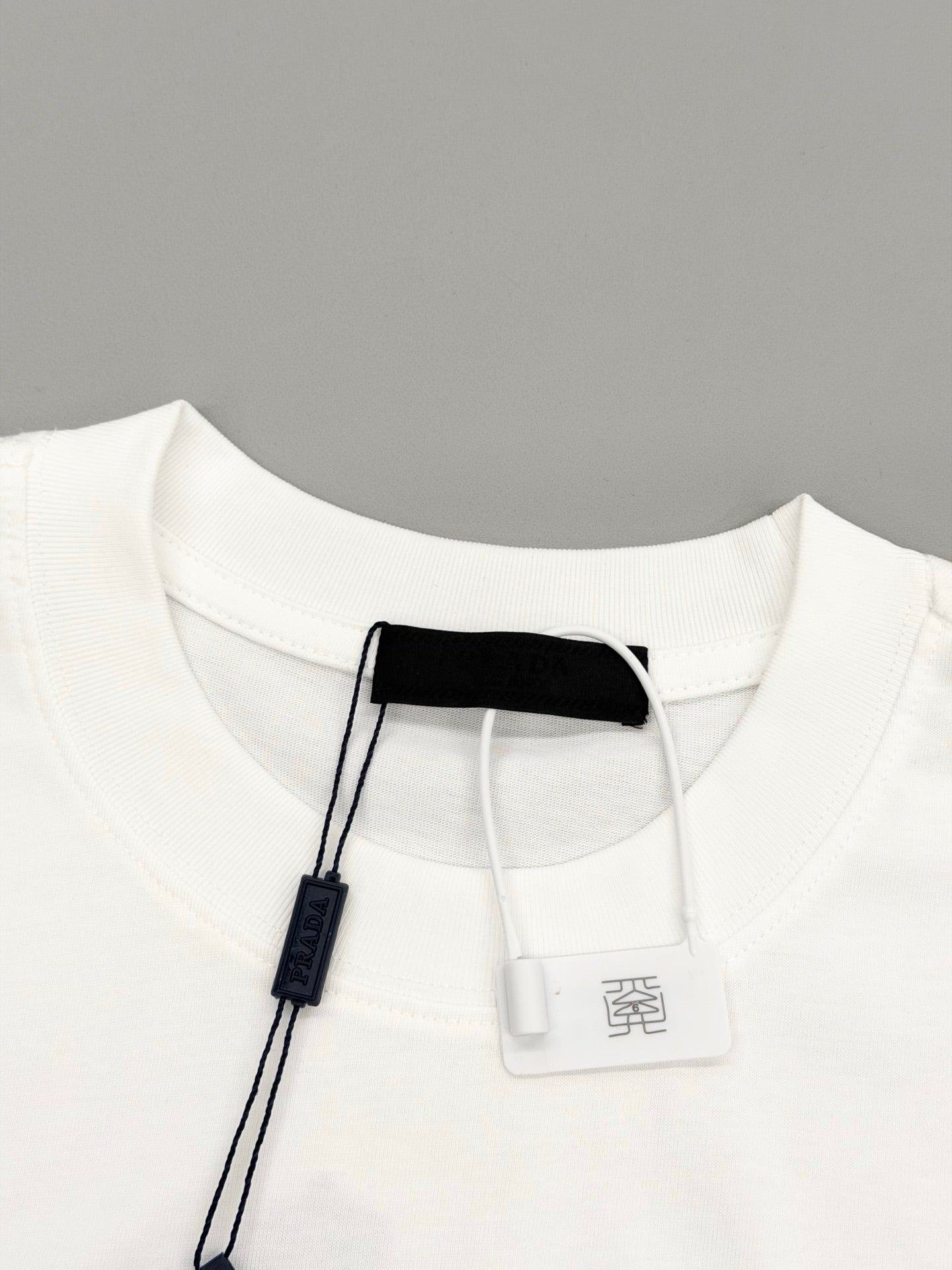 White short-sleeve T-shirt neckline with attached hang tag