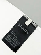 Black PRADA size and care label inside white T-shirt hem