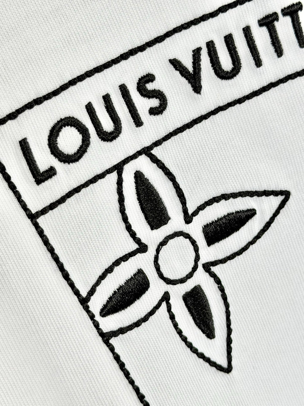White knit fabric with embroidered Louis Vuitton logo and flower emblem