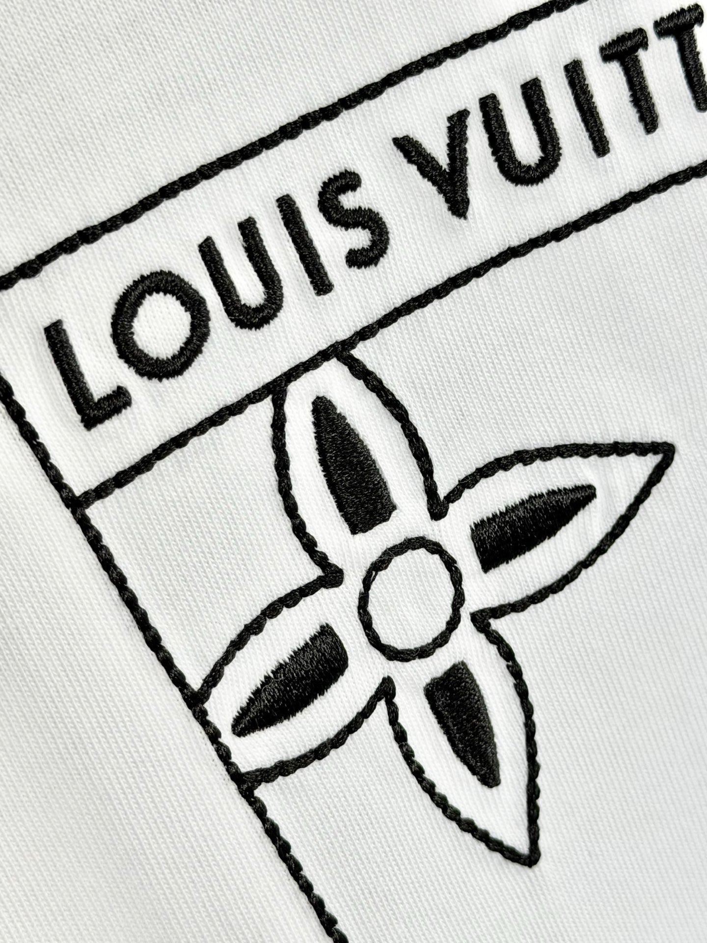 White knit fabric with embroidered Louis Vuitton logo and flower emblem