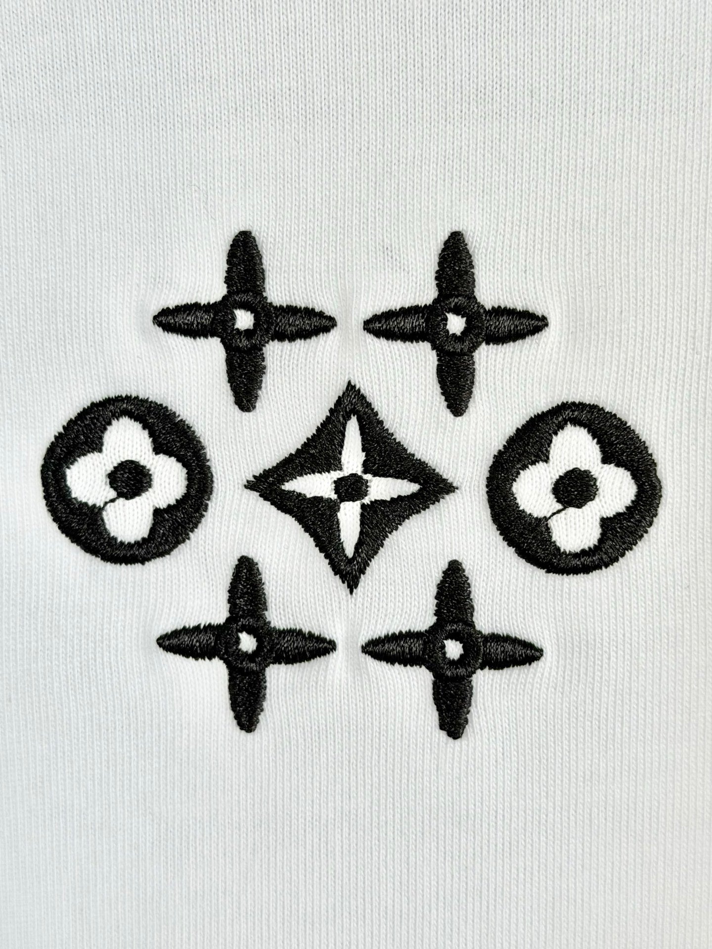 White knit fabric with black geometric flower and star pattern