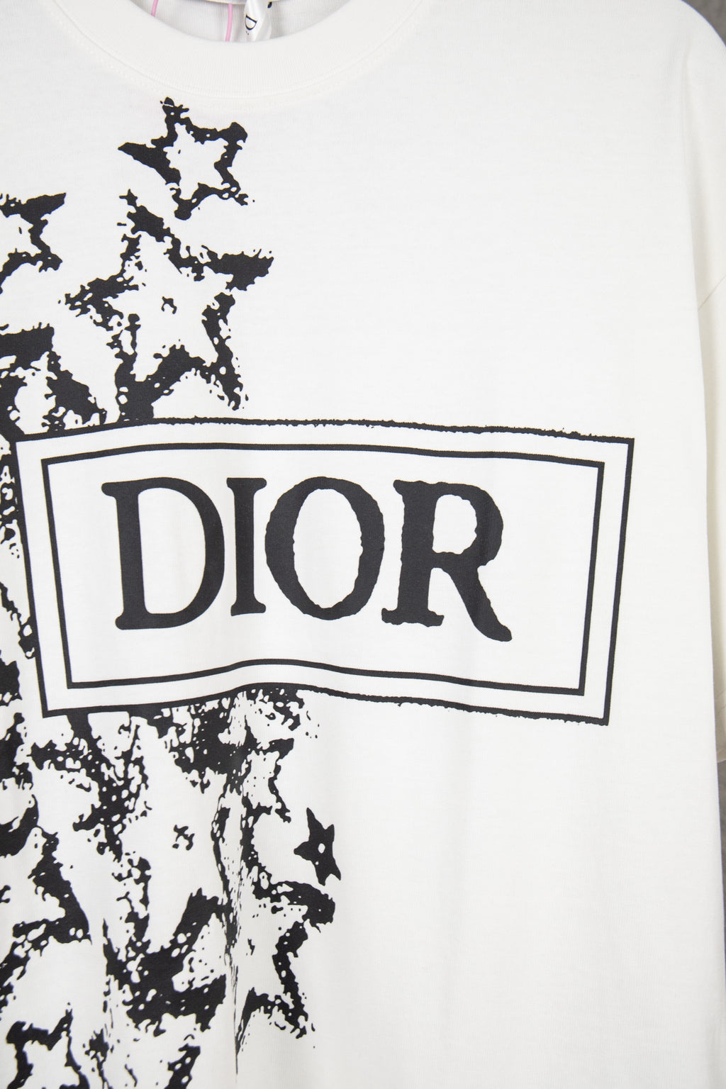 White short-sleeve T-shirt close-up of Dior logo box with black starburst graphic