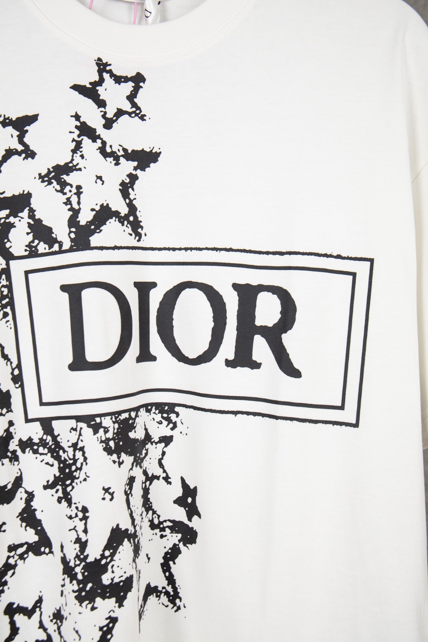 White short-sleeve T-shirt close-up of Dior logo box with black starburst graphic